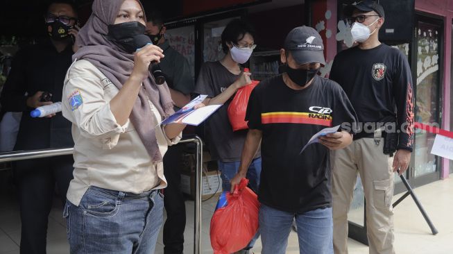 Warga mendapatkan paket sembako usai menjalani vaksin COVID-19 di Rusun Petamburan, Tanah Abang, Jakarta, Kamis (22/7/2021). [Suara.com/Angga Budhiyanto]