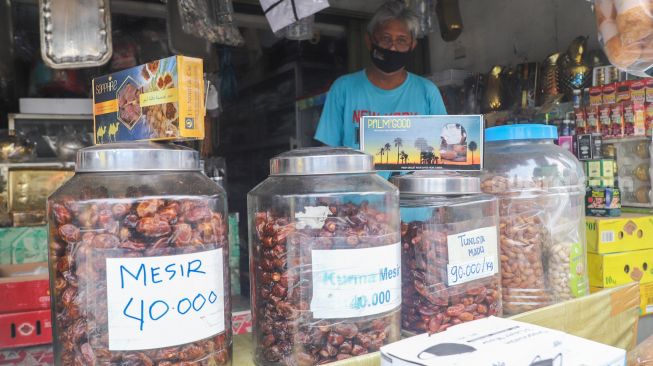 Pedagang oleh-oleh khas haji menunggu pembeli di sekitar kawasan Asrama Haji Pondok Gede, Jakarta Timur, Kamis (22/7/2021). [Suara.com/Alfian Winanto] 