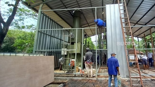 Para pekerja saat mempersiapkan mesin krematorium jenazah Covid-19 di TPU Tegal Alur, Jakbar. (Suara.com/Arga)