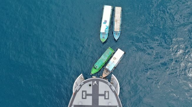 Perahu nelayan yang membawa warga Pulau Pramuka dan Pulau Panggang merapat ke haluan KRI Teluk Youtefa-522 yang lego jangkar saat Operasi Serbuan Vaksinasi Masyarakat Maritim di Perairan Kepulauan Seribu, Jakarta, Jumat (23/7/2021). ANTARA FOTO/M Risyal Hidayat