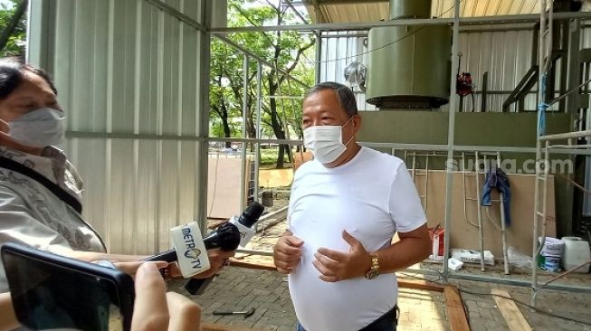 Ketua Umum Perkumpulan Sosial Himbunan Bersatu Teguh  Andreas Sofiandi saat menjelaskan soal mesin krematorium jenazah Covid-19 di TPU Tegal Alur. (Suara.com/Arga)