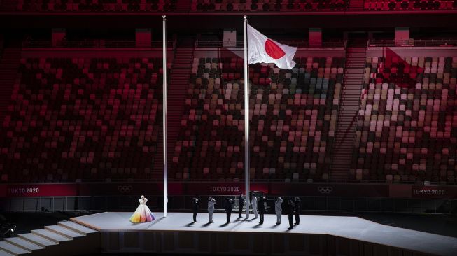 Petugas mengibarkan bendera Jepang dalam pembukaan Olimpiade Tokyo 2020 di Stadion Nasional, Tokyo, Jepang, Jumat (23/7/2021). [ANTARA FOTO/Sigid Kurniawan]