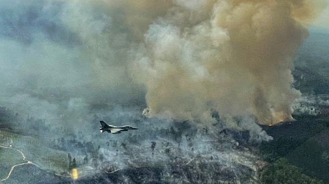 Pesawat tempur F-16 dari Skadron Udara 16/Rydder Lanud Roesmin Pekanbaru, terbang diatas lahan yang terbakar di Koto Tuo, Kampar, Riau, Rabu (21/7/2021).  [ANTARA FOTO]