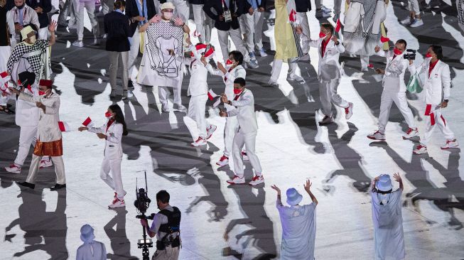 Kontingen Indonesia mengikuti defile dalam pembukaan Olimpiade Tokyo 2020 di Stadion Nasional, Tokyo, Jepang, Jumat (23/7/2021). [ANTARA FOTO/Sigid Kurniawan]