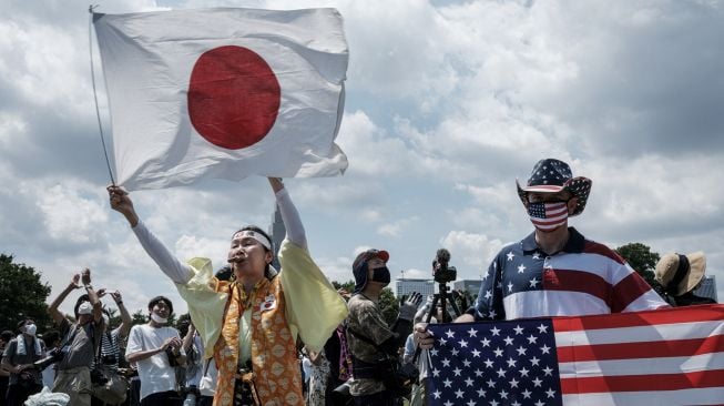 Penggemar berat Olimpiade Kyoko Ishikawa yang telah menghadiri setiap Olimpiade Musim Panas dalam 30 tahun terakhir, mengungkapkan rasa terima kasihnya saat Blue Impulse, tim aerobatik Angkatan Udara Bela Diri Jepang (JASDF), melakukan pertunjukan membentuk cincin Olimpiade di langit Tokyo, pada (23/7/2021). [Yasuyoshi CHIBA / AFP]