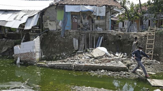 Warga melihat kondisi rumah yang rusak akibat longsor di Desa Kertasmaya, Indramayu, Jawa Barat, Sabtu (24/7/2021). [ANTARA FOTO/Dedhez Anggara]