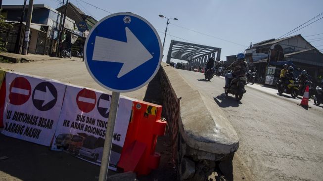 Sejumlah pengendara melintas pada sisi jalur Jembatan Sungai Citarum yang ditutup di Jalan Raya Dayeuhkolot, Kabupaten Bandung, Jawa Barat, Minggu (25/7/2021).  ANTARA FOTO/Novrian Arbi