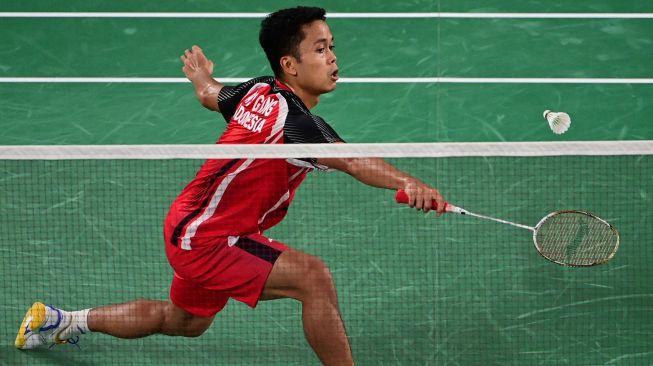 Pebulutangkis tunggal putra Indonesia Anthony Ginting mengembalikan shuttlecock ke arah lawannya pebulutangkis tunggal putra Hongaria Gergely Krausz dalam laga Tunggal Putra Grroup J Olimpiade Tokyo 2020, di Musashino Forest Sport Plaza, Tokyo,, Jepang, Minggu (25/7/2021). [AFP]