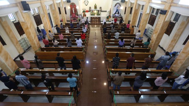 Umat kristiani melaksanakan ibadah dengan menjaga jarak dan memakai masker sebagai bagian pelaksanaan protokol kesehatan (prokes) COVID-19 di gereja Hati Kudus, Banda Aceh, Aceh, Minggu (25/7/2021). ANTARA FOTO / Irwansyah Putra