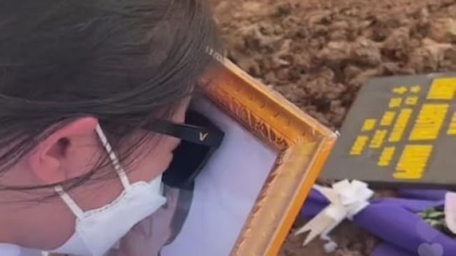 Sambil memeluk foto, Amanda Manopo tak kuasa menahan tangis di pemakaman sang ibu, Henny Manopo di Pemakaman San Diego Hills, Karawang, Jawa Barat, Senin (26/7/2021). [Instagram]