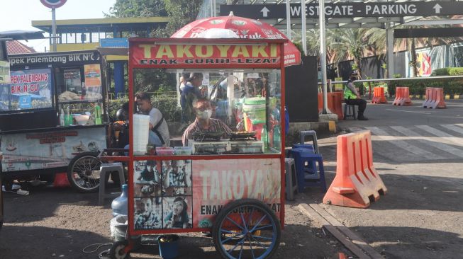 Pedagang kaki lima menunggu pembeli di sekitar kawasan Sudirman, Jakarta Pusat, Senin (26/7/2021). [Suara.com/Alfian Winanto]