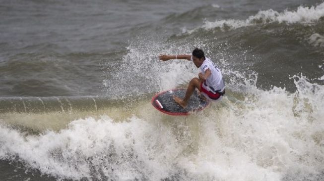 Peselancar Indonesia Rio Waida berkompetisi dalam Heat 1 selancar putra papan pendek dalam Olimpiade Tokyo 2020 di Tsurigasaki Surfing Beach, Tokyo, Jepang, Minggu (25/7/2021). [AFP]