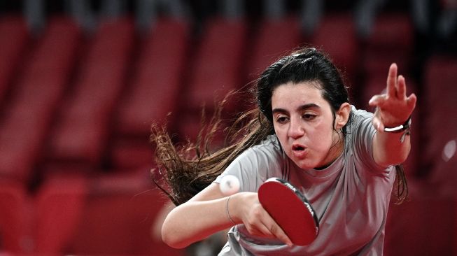 Petenis meja Suriah Hend Zaza mengembalikan pukulan Liu Jia dari Austria selama pertandingan babak penyisihan tunggal tenis meja putri di Olimpiade 2020, Tokyo, Jepang, Sabtu (24/7). [AFP]