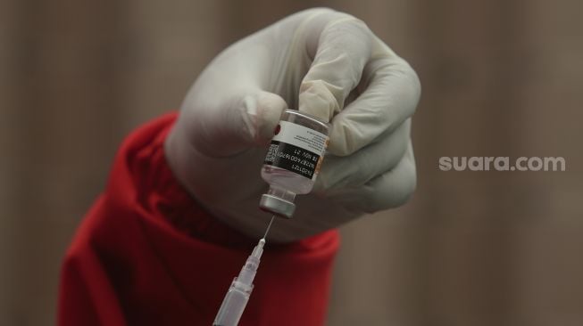 Vaksinator mempersiapkan vaksin COVID-19 sebelum disuntikkan kepada warga di Universitas Nasional, Jakarta, Senin (26/7/2021). [Suara.com/Angga Budhiyanto]