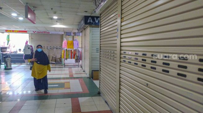 Warga belanja di Blok B Pasar Tanah Abang, Jakarta Pusat, Senin (26/7/2021). [Suara.com/Alfian Winanto]