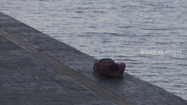 Warga berolahraga di kawasan Danau Sunter, Jakarta, Selasa (27/7/2021). [Suara.com/Angga Budhiyanto]