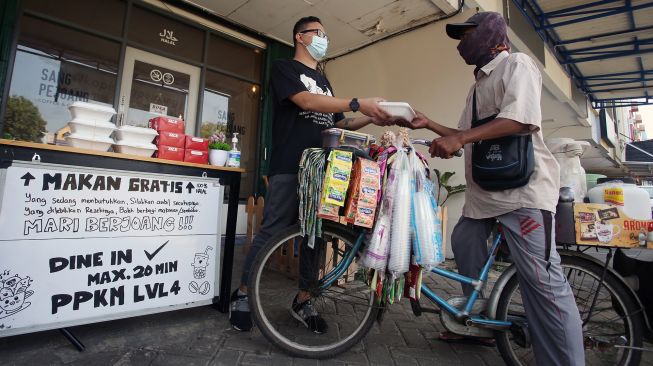 Seorang pemilik kedai kopi memberikan makan siang gratis kepada pedagang kopi keliling di Gading Serpong, Tangerang, Banten, Selasa (27/7/2021). ANTARA FOTO/Muhammad Iqbal
