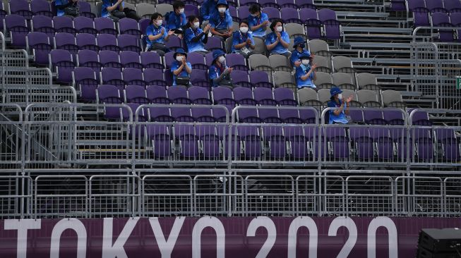 Seorang petugas duduk di tribun media saat berlangsung pertandingan panahan Olimpiade Tokyo 2020 di Yumenoshima Park Archery Field, Tokyo, Jepang, Senin (26/7/2021).  ANTARA FOTO/Sigid Kurniawan