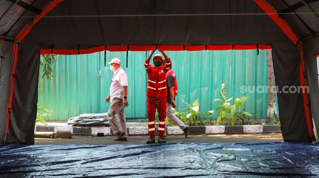 Petugas memeriksa kesiapan tenda atau selter untuk isolasi mandiri bagi masyarakat di Jl. Gatot Subroto Kav 97 RW 4, Mampang Prapatan, Jakarta Selatan, Selasa (27/7/2021). [Suara.com/Alfian Winanto]