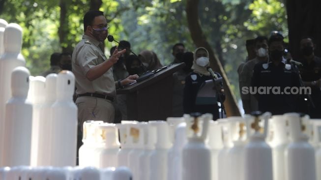 Gubernur DKI Jakarta Anies Baswedan memberikan keterangan saat penyerahan barang bukti tabung oksigen hasil pengungkapan kasus tindak kejahatan di Monas, Jakarta, Selasa (27/7/2021). [Suara.com/Angga Budhiyanto]