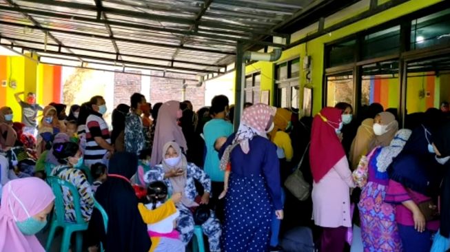 Ratusan warga berdesakan di tempat pembagian BLT di Baperkam Kelurahan Karyamulya, Kota Cirebon, Selasa (27/7/2021). [Suara.com/Abdul Rohman]