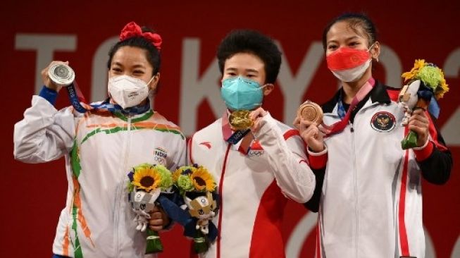 Chanu Mirabai dan Windy Cantika saat meraih medali di Olimpiade Tokyo 2020. (VINCENZO PINTO / AFP)