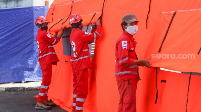 Petugas memeriksa kesiapan tenda atau selter untuk isolasi mandiri bagi masyarakat di Jl. Gatot Subroto Kav 97 RW 4, Mampang Prapatan, Jakarta Selatan, Selasa (27/7/2021). [Suara.com/Alfian Winanto]