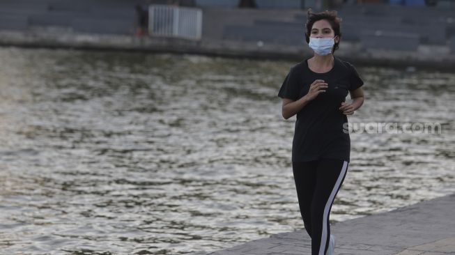 Warga berolahraga di kawasan Danau Sunter, Jakarta, Selasa (27/7/2021). [Suara.com/Angga Budhiyanto]