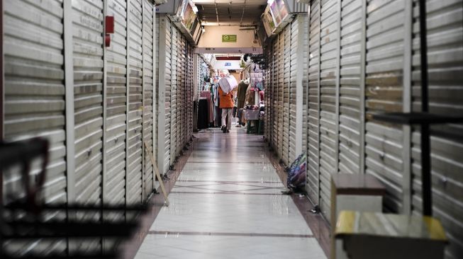 Portir memanggul barang di Pasar Tanah Abang, Jakarta, Senin (26/7/2021). ANTARA FOTO/Hafidz Mubarak