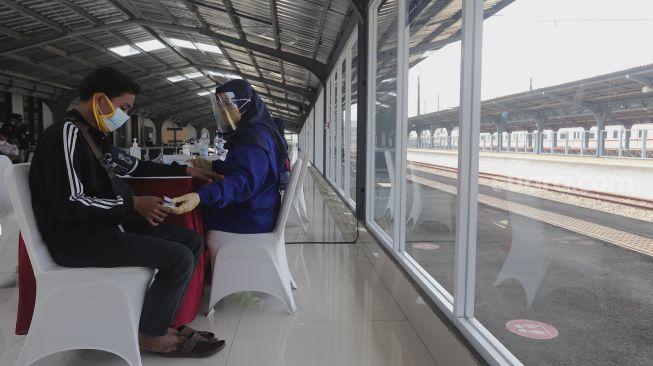 Tenaga kesehatan memeriksa kondisi kesehatan warga yang akan mendapatkan vaksin COVID-19 di Stasiun Jakarta Kota, Jakarta, Rabu (28/7/2021). [Suara.com/Angga Budhiyanto]
