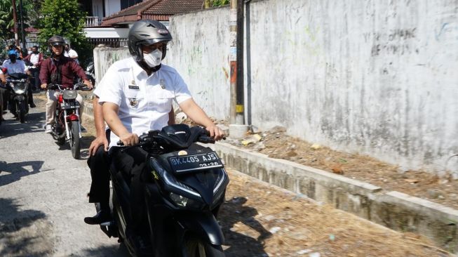 Naik Kereta Matic, Bobby Nasution Bagikan Sembako ke Warga di Medan