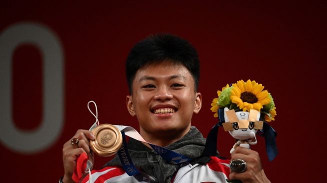Lifter Indonesia, Rahmat Erwin Abdullah merebut medali perunggu di Olimpiade Tokyo lalu. [Vincenzo PINTO / AFP]