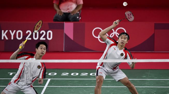 Pebulutangkis ganda putra Indonesia Marcus Fernaldi Gideon/Kevin Sanjaya Sukamuljo mengembalikan kok ke arah ganda putra Malaysia Aaron Chia/Wooi Yik Soh dalam perempat final Olimpiade Tokyo 2020 di Musashino Forest Sport Plaza, Tokyo, Jepang, Kamis (29/7/2021). ANTARA FOTO/Sigid Kurniawan