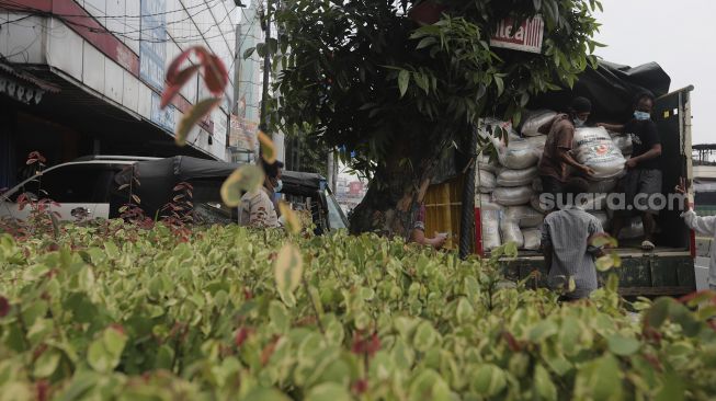 Pengurus RT memindahkan beras yang siap disalurkan kepada warga di RW 03 Kelurahan Tanah Tinggi, Kecamatan Johar Baru, Jakarta, Kamis (29/7/2021). [Suara.com/Angga Budhiyanto]