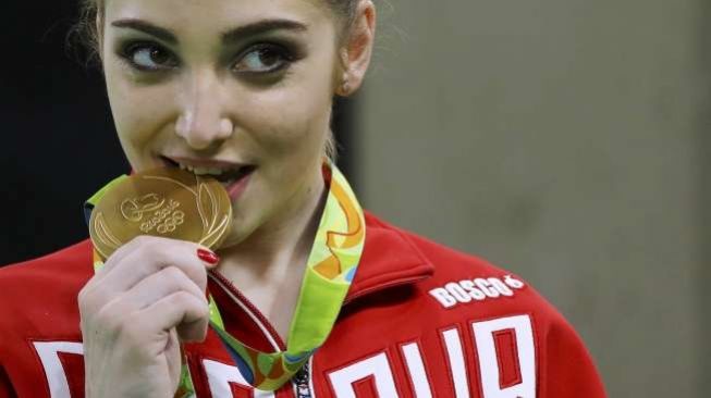 Para atlet Olimpiade menggigit medali emas yang mereka peroleh. (Reuters)