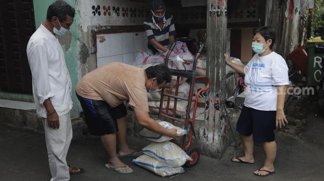 Pengurus RT bersiap menyalurkan bantuan sosial non tunai berupa beras kepada warga di RW 03 Kelurahan Tanah Tinggi, Kecamatan Johar Baru, Jakarta, Kamis (29/7/2021). [Suara.com/Angga Budhiyanto]