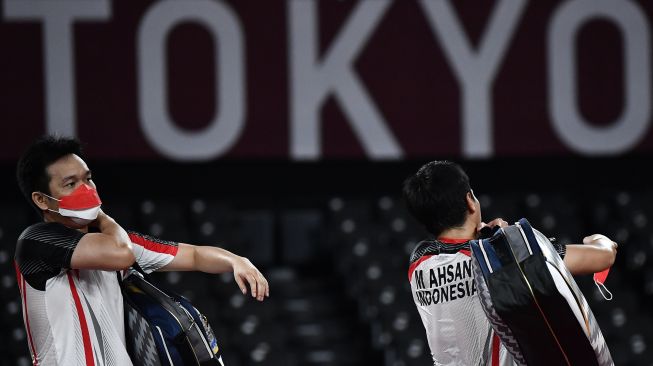 Pebulutangkis ganda putra Indonesia Mohammad Ahsan/Hendra Setiawan bersiap meninggalkan lapangan seusai kalah dari ganda putra Taiwan Lee Yang/Wang Chi-Lin dalam semifinal Olimpiade Tokyo 2020, di Musashino Forest Sport Plaza, Tokyo, Jepang, Jumat (30/7/2021). [ANTARA FOTO/Sigid Kurniawan]