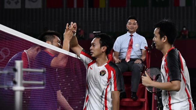 Pebulutangkis ganda putra Indonesia Mohammad Ahsan/Hendra Setiawan memberikan selamat kepada ganda putra Taiwan Lee Yang/Wang Chi-Lin seusai semifinal Olimpiade Tokyo 2020, di Musashino Forest Sport Plaza, Tokyo, Jepang, Jumat (30/7/2021). [ANTARA FOTO/Sigid Kurniawan]