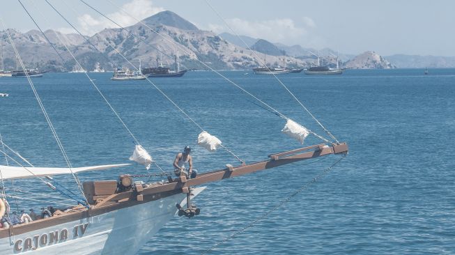 Sebuah kapal wisata pinisi melintas di perairan dekat Dermaga Labuan Bajo, Manggarai Barat, Nusa Tenggara Timur, Jumat (30/7/2021). [ANTARA FOTO/Muhammad Adimaja]