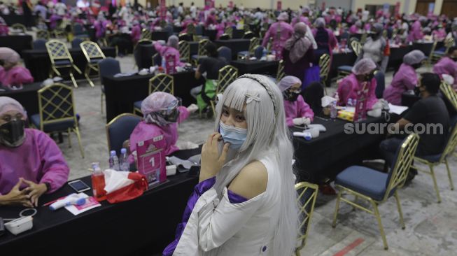 Warga mengenakan kostum tokoh fiksi anime Jepang menunggu giliran untuk mendapatkan vaksinasi COVID-19 di Jakarta Convention Center (JCC), Senayan, Jakarta, Sabtu (31/7/2021). [Suara.com/Angga Budhiyanto]