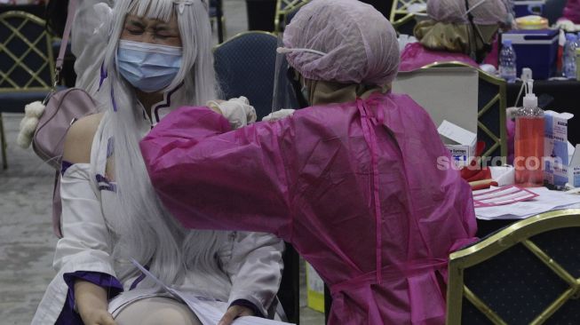 Vaksinator menyuntikkan vaksin COVD-19 kepada warga yang mengenakan kostum tokoh fiksi anime Jepang di Jakarta Convention Center (JCC), Senayan, Jakarta, Sabtu (31/7/2021). [Suara.com/Angga Budhiyanto]