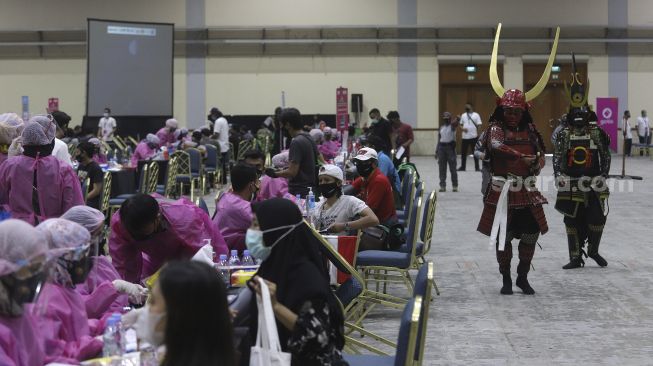 Relawan berkostum tokoh fiksi anime Jepang berjalan di area vaksinasi COVID-19 di Jakarta Convention Center (JCC), Senayan, Jakarta, Sabtu (31/7/2021). [Suara.com/Angga Budhiyanto]