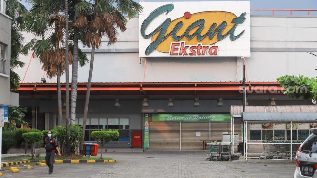 Suasana di depan gerai Giant yang ditutup di Pondok Gede, Bekasi, Jawa Barat, Minggu (1/8/2021). [Suara.com/Alfian Winanto]