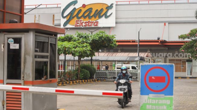 Suasana di depan gerai Giant yang ditutup di Pondok Gede, Bekasi, Jawa Barat, Minggu (1/8/2021). [Suara.com/Alfian Winanto]