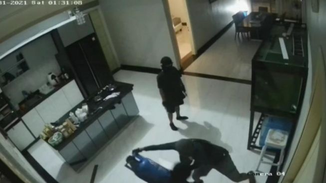 Rekaman CCTV saat para perampok bertopeng berusaha menjebol pintu kamar dengan tabung gas. [Presisi.co]