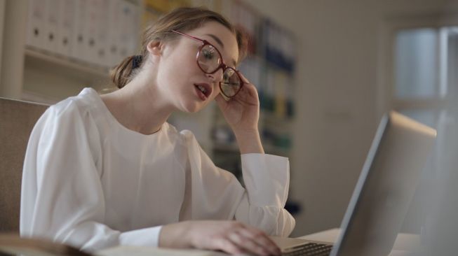 Ilustrasi wanita menggunakan laptop untuk menulis.  (pexels.com/Andrea Piacquadio)