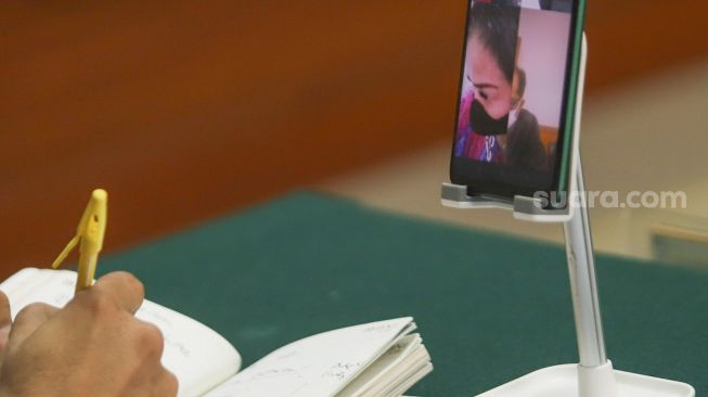 Jennifer Jill saat menajalani sidang kasus narkoba secara virtual melalui sambungan video call di Pengadilan Negeri Jakarta Barat, Senin (2/8/2021). [Suara.com/Alfian Winanto]