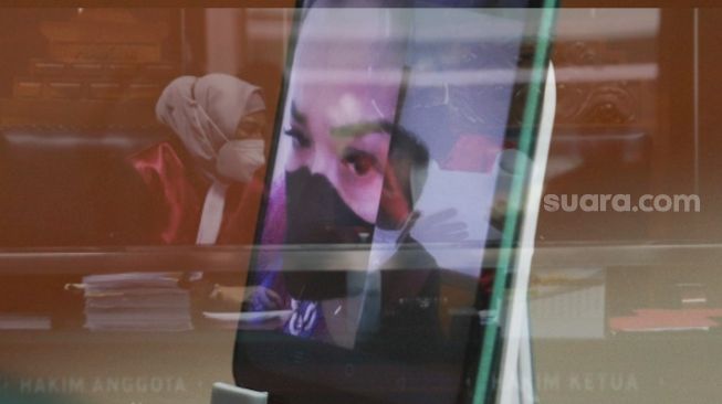 Foto Double Eksposure Jennifer Jill saat menajalani sidang kasus narkoba secara virtual di Pengadilan Negeri Jakarta Barat, Senin (2/8/2021). [Suara.com/Alfian Winanto]