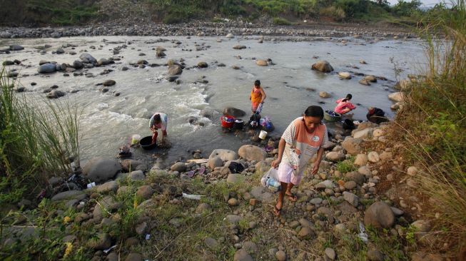 Warga mencuci pakaian di aliran Sungai Cipamingkis yang menyusut di Jonggol, Kabupaten Bogor, Jawa Barat, Selasa (3/8/2021).  ANTARA FOTO/Yulius Satria Wijaya