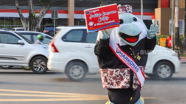 Maskot Hari Konsumen Nasional (Harkonas) Si Enda melakukan aksi kampanye kepada pengendara di kawasan Tugu Tani, Jakarta Pusat, Selasa (3/8/2021). [Suara.com/Alfian Winanto]